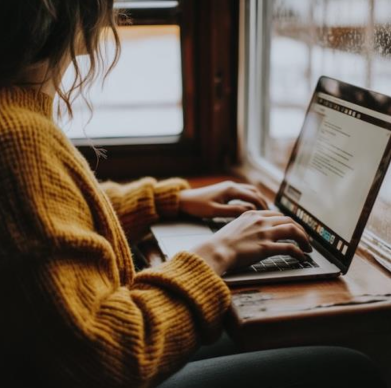 Woman typing at laptop.